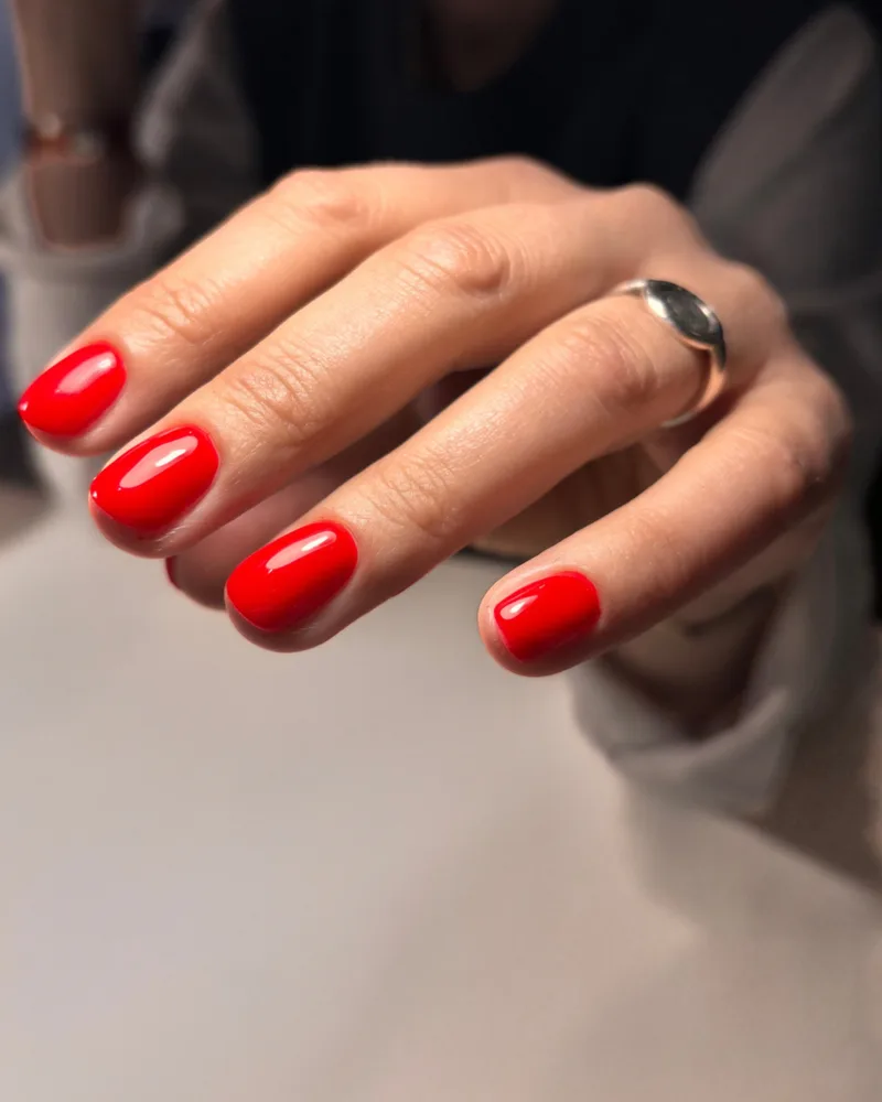 Semi-permanent rouge vif sur ongles courts carrés arrondis