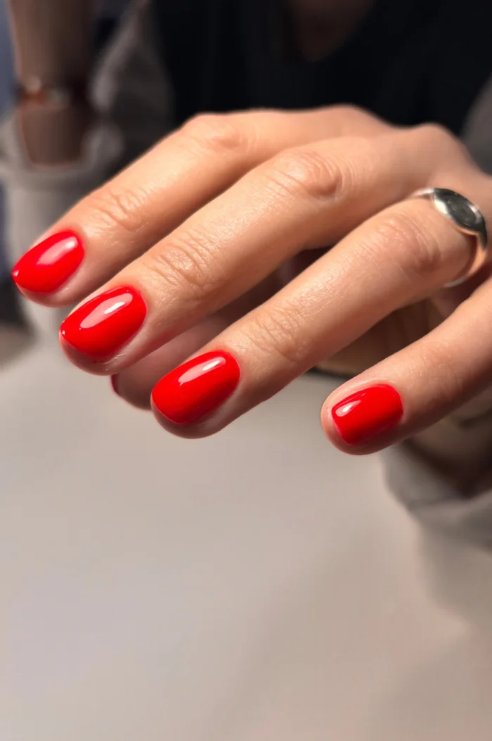 Semi-permanent rouge vif sur ongles courts, finition brillante